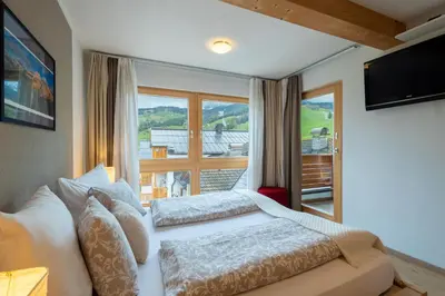 a bedroom with a bed and a large window at Apartments Irene in La Villa