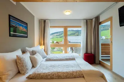 a bedroom with a bed and a large window at Apartments Irene in La Villa