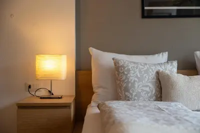 a bedroom with a bed and a lamp on a night stand at Apartments Irene in La Villa