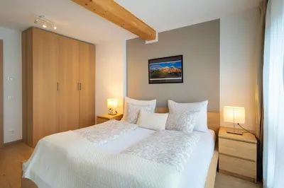 a bedroom with a large white bed with two lamps at Apartments Irene in La Villa