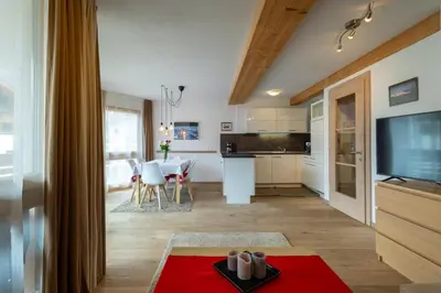 a kitchen and living room with a red rug at Apartments Irene in La Villa