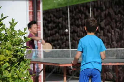 a young boy playing a game of table tennis at Apartments Dolina in Ortisei