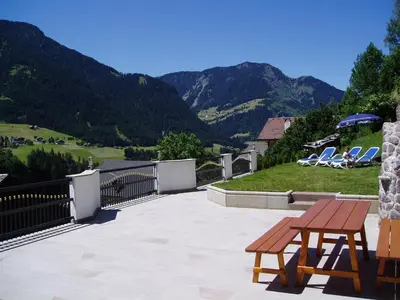 a patio with a table and chairs and mountains at Apartments Dolina in Ortisei