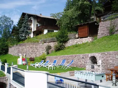 a group of chairs sitting in a yard next to a building at Apartments Dolina in Ortisei