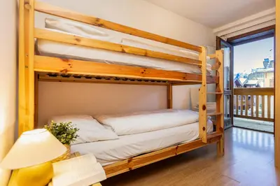 two bunk beds in a room with a balcony at Ciasa de Vich in Vigo di Fassa