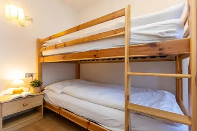a bedroom with two bunk beds and a desk at Ciasa de Vich in Vigo di Fassa