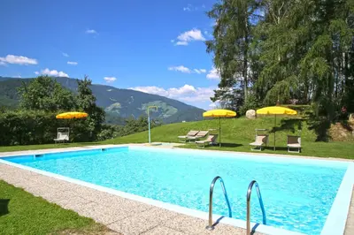 a large house on top of a green hill at Hotel Pichlerhof in San Lorenzo di Sebato