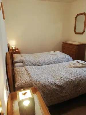 a bedroom with two beds and a table with a mirror at Cesa de Conesel in Colle Santa Lucia