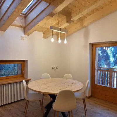 a dining room with a wooden table and chairs at Cesa de Conesel in Colle Santa Lucia