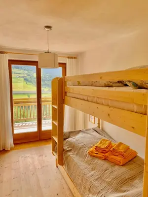 a bedroom with two bunk beds and a large window at Apartment HaNiLe in Sarntal