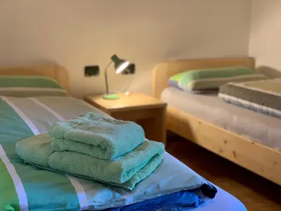 a room with two beds with towels on a table at Apartment HaNiLe in Sarntal
