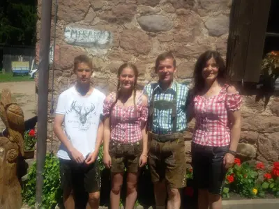 a group of people standing in front of a stone wall at Pitterle Hof in Meltina