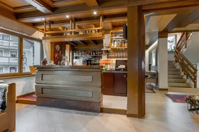 a bar with a piano in the middle of a room at Albergo Contrin in Campitello