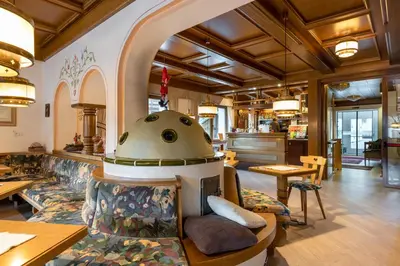 a restaurant with a pizza oven in the middle at Albergo Contrin in Campitello