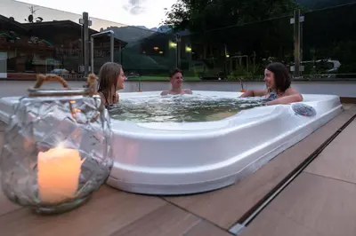 a group of women sitting in a hot tub at Albergo Contrin in Campitello