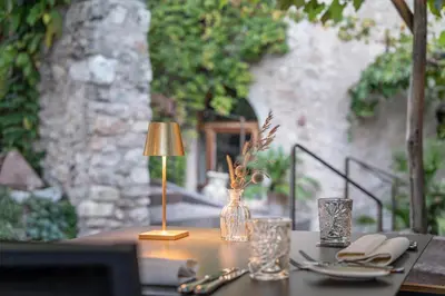 a table with a lamp and glasses on a table at Ansitz Romani in Termeno