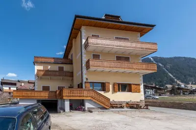 a large building with wooden balconies on it at Casa Carnevali in Pozza di Fassa