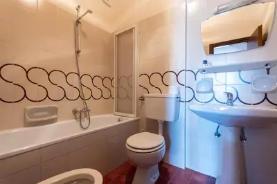 a bathroom with a toilet and a sink and a tub at Casa Carnevali in Pozza di Fassa