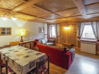 a living room with a table and a couch and a table and chairs at Casa Cristina in Campitello di Fassa