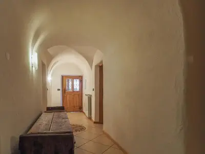 an empty hallway with a table and a door at Casa Cristina in Campitello di Fassa