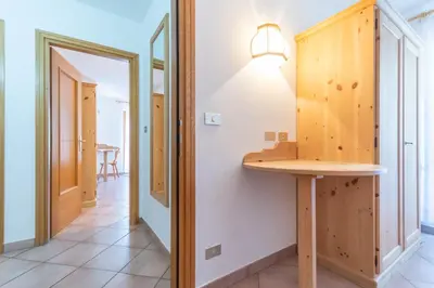 a hallway with a table and a mirror at Casa Fanton in Pozza di Fassa