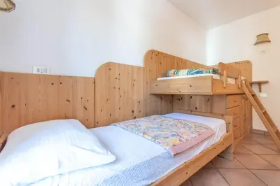 a bedroom with two bunk beds and a ladder at Casa Fanton in Pozza di Fassa