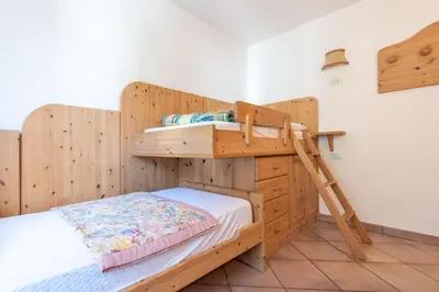 a wooden bunk bed with a ladder in a room at Casa Fanton in Pozza di Fassa