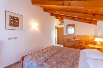 a bedroom with a bed and a wooden ceiling at Casa Fanton in Pozza di Fassa