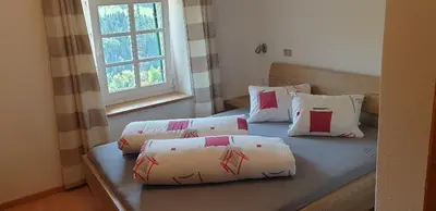 a bedroom with two beds with pillows and a window at Hofer Hof in Castelrotto