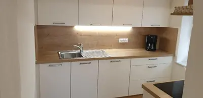a kitchen with white cabinets and a sink at Hofer Hof in Castelrotto