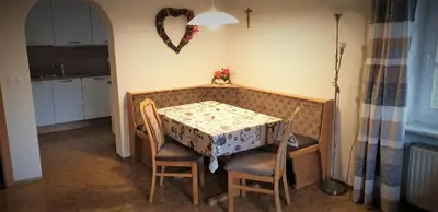a dining room table and chairs with a heart on the wall at Hofer Hof in Castelrotto