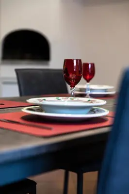 a table with a plate and two glasses of red wine at Apartment Goethe 1 in Bolzano