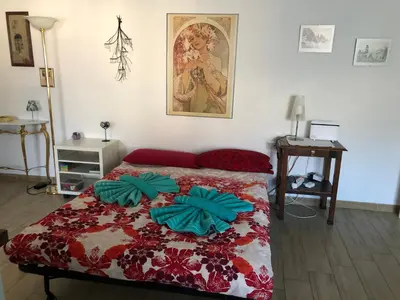 a bedroom with a bed with a red and green comforter at Casa Turchese in Merano