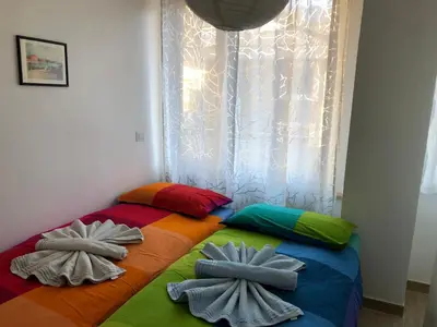 a bed with colorful pillows on it with a window at Casa Turchese in Merano