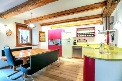 a kitchen with a wooden table and a dining room at Chalet Tobià Villa in Canazei