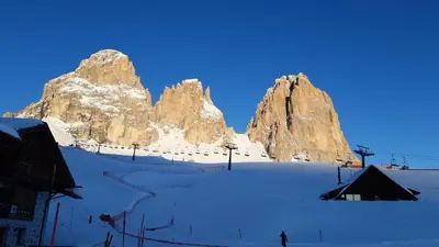 a person on skis in the snow in front of a mountain at Chalet Tobià Villa in Canazei