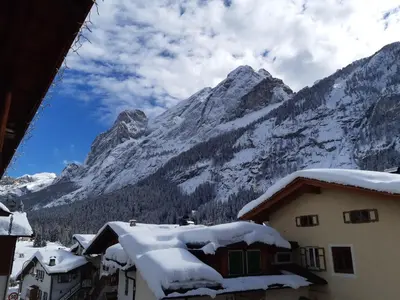 a view of a mountain with snow on the roofs of houses at Chalet Tobià Villa in Canazei