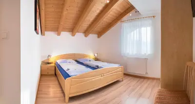 a bedroom with a bed and a wooden ceiling at St. Urbanhof in Termeno