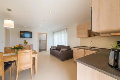 a kitchen and living room with a table and a couch at St. Urbanhof in Termeno
