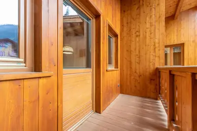 a hallway of a wooden cabin with a window at Casa Sartori in Pozza di Fassa