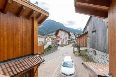 a car parked on a street next to buildings at Casa Sartori in Pozza di Fassa