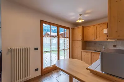 a kitchen with a table and a window at Casa De La Veisc in Pozza di Fassa