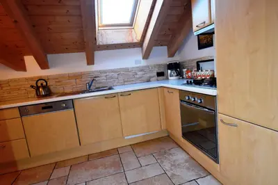 a kitchen with wooden cabinets and a stove at Chalet alla Cascata in Badia