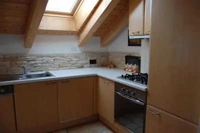 a small kitchen with a sink and a stove at Chalet alla Cascata in Badia