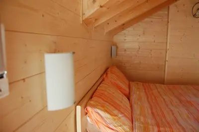 a small room with a bed in a wooden cabin at Chalet alla Cascata in Badia
