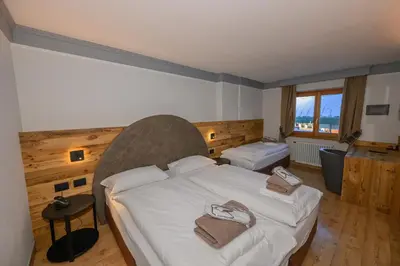 a bedroom with a large bed with towels on it at Hotel Tita Piaz in Canazei