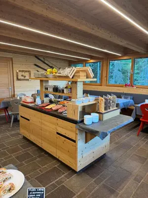 a kitchen with a counter in a room with windows at Hotel Tita Piaz in Canazei
