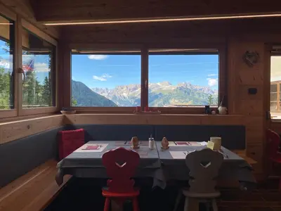 a table in a restaurant with a view of mountains at Hotel Tita Piaz in Canazei
