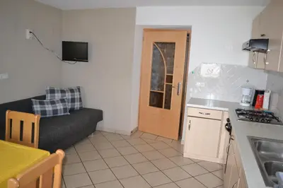 a kitchen and a living room with a couch and a table at Gruberhof in Rodengo