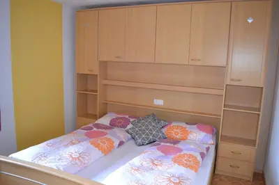 a small bedroom with a bed with wooden cabinets at Gruberhof in Rodengo